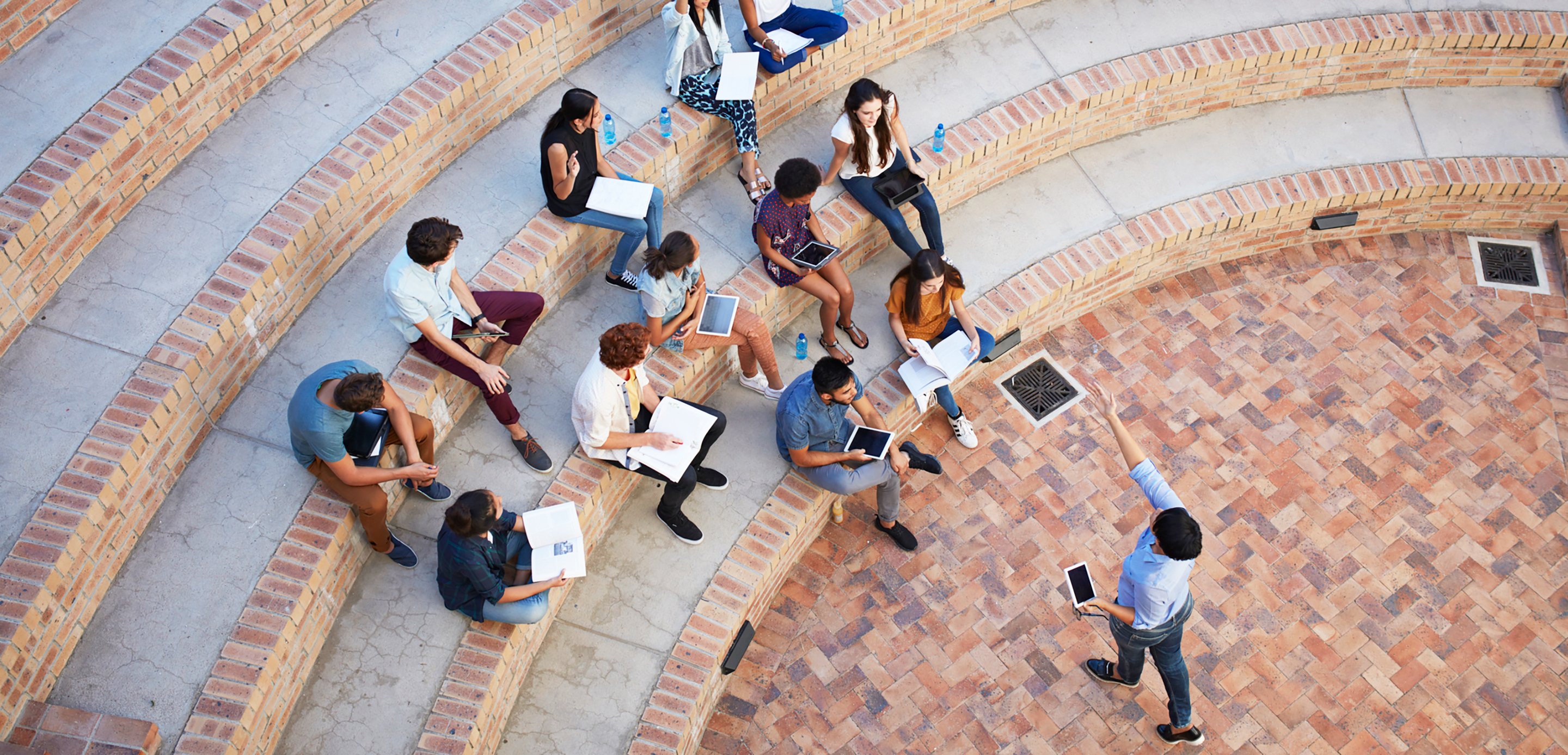 Group of colleagues using laptops and tablets to conduct an agile outside meeting outside Group of colleagues using laptops and tablets to conduct an agile outside meeting outside