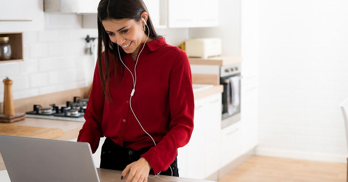 Woman looking at laptop in kitchen